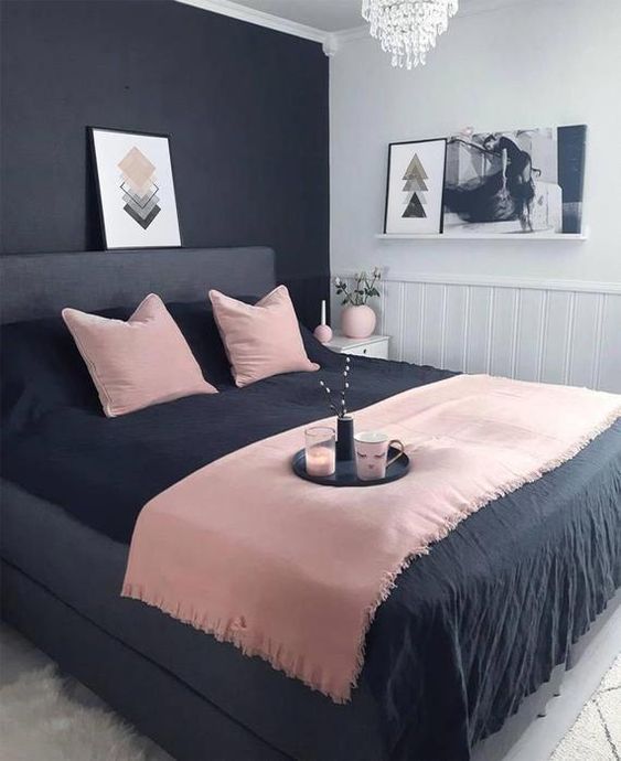 Painting the wall half black and half white is a smart decorating trick. It highlights the grey bed and the soft pink blanket perfectly. With the geometric art on the shelf, this pink and black bedroom looks very modern.