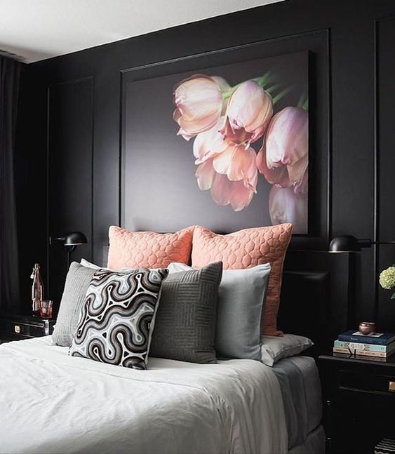 The large art piece with pink tulips looks beautiful against the dark wall molding. It adds a soft touch to this moody pink and black bedroom.
