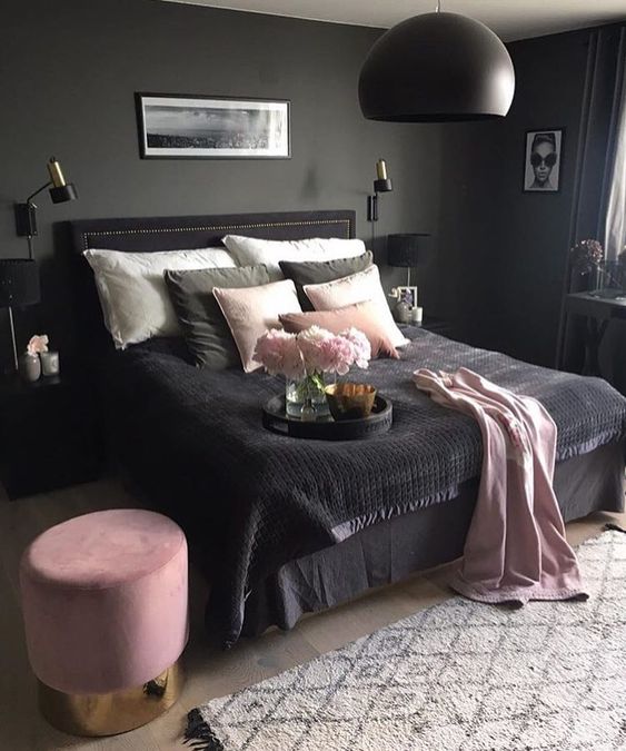 Fresh pink flowers on the dark bedspread look lovely. That small velvet stool with the gold base is a very chic detail in this pink and black bedroom.