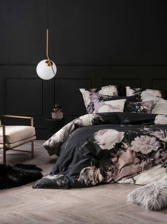 This room is so moody and dramatic with the dark walls and bedding. The large white flower print on the duvet keeps it from looking too dark. A single round light hanging down is the perfect finish for this chic pink and black bedroom.