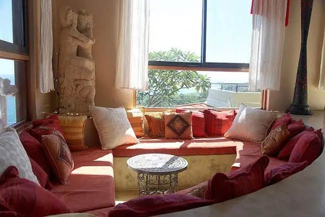 All the red and orange pillows make this round conversation pit look very warm.