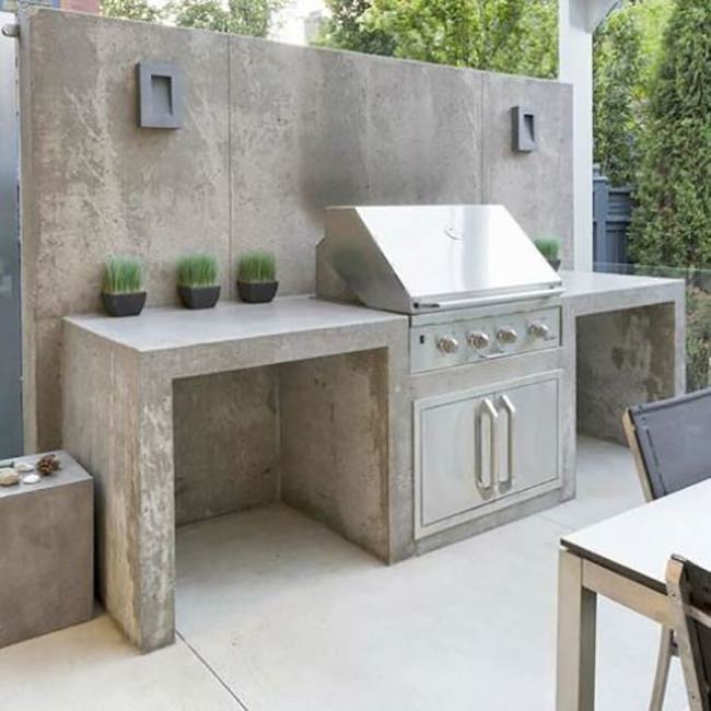This all-concrete kitchen is super minimalist and durable. The thick countertops and simple stainless steel doors create a clean, industrial look. It’s perfect for a modern backyard that needs a no-fuss cooking station.