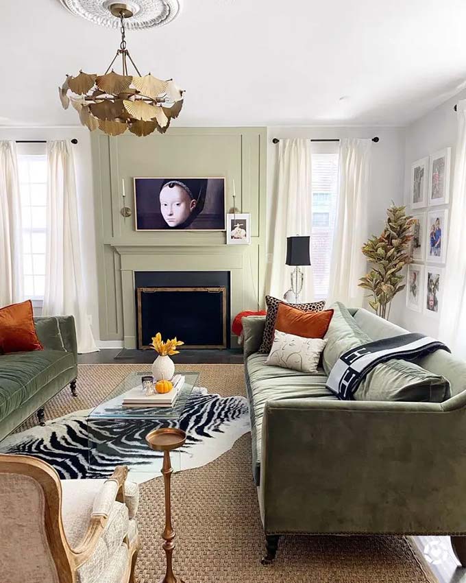 Soft green molding frames the screen so it looks just like a piece of art. The gold chandelier adds a fancy touch to the formal room. Using a Frame TV that displays pictures makes the technology disappear into the beautiful wall. It creates a very elegant TV wall decor style.