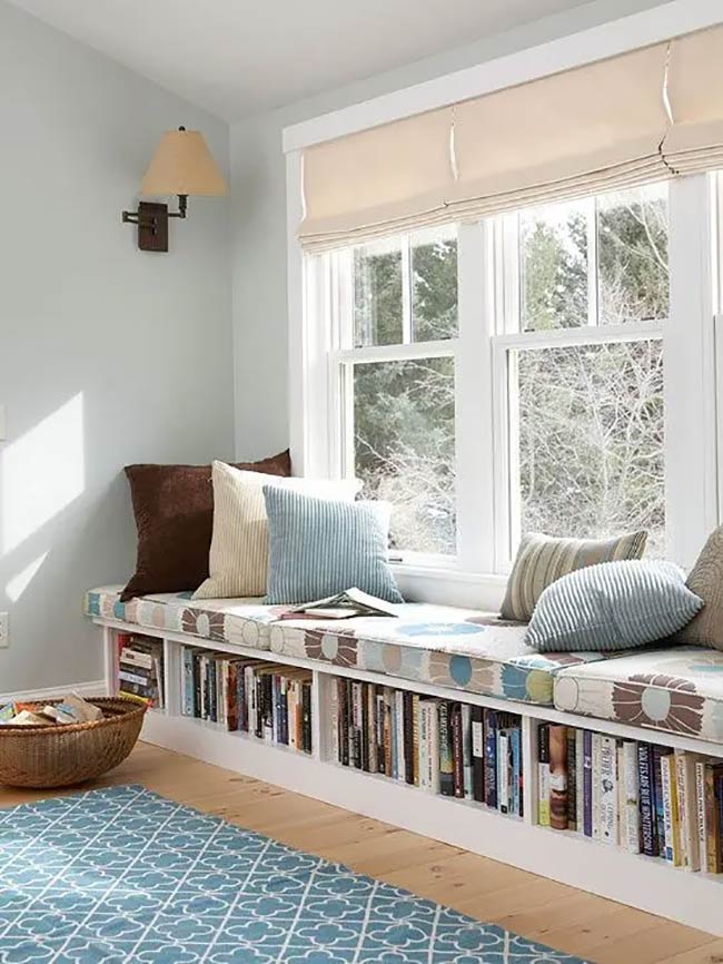 This built-in bench is the perfect spot for a reader to relax. The open cubbies underneath hold a huge collection of books right where you need them. With the soft cushions and patterned rug, this under window storage turns a plain wall into a comfy library.